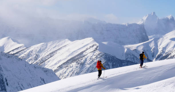 narciarze backcountry wznoszą się rano na śnieżny grzbiet górski - skiing snow ski slope sunlight zdjęcia i obrazy z banku zdjęć