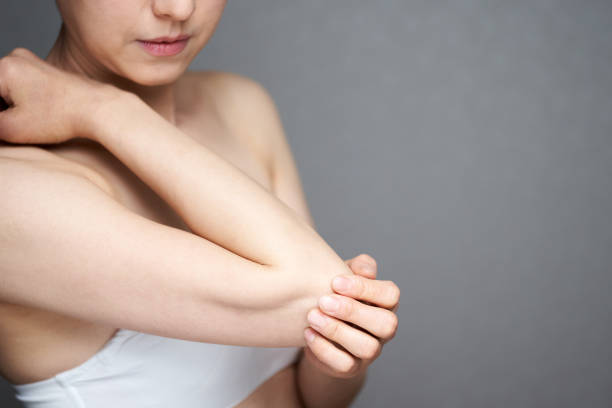 Middle-aged Japanese woman suffering from elbow problems Middle-aged Japanese woman suffering from elbow problems human limb stock pictures, royalty-free photos & images