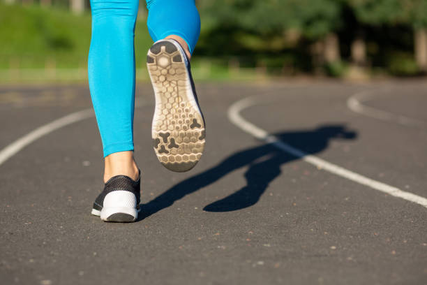 istock Woman athlete legs during running workout train on the stadium. Copy space 1307113817