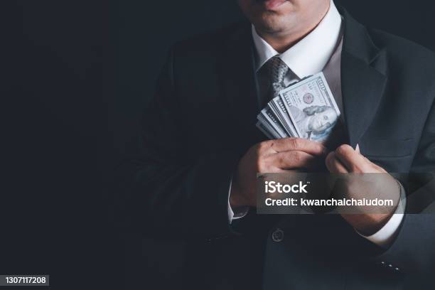 Man Putting Bribe Money Into Pocket On Black Background Stock Photo - Download Image Now