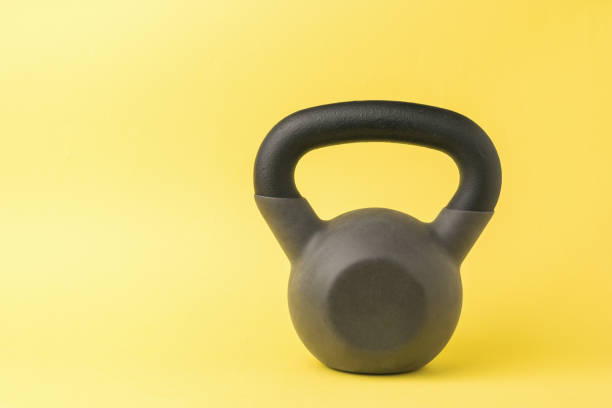 istock Stylish sports kettlebell on a bright yellow background. 1307118097