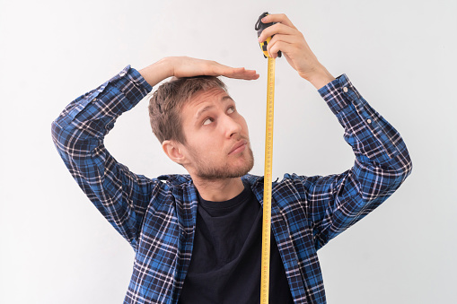 simple adolescente adulto persona masculina con una cinta adhesiva miden la altura contra la pared photo
