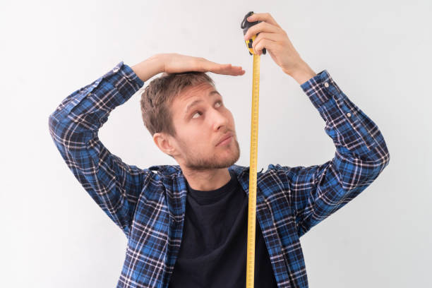 simple adolescente adulto persona masculina con una cinta adhesiva miden la altura contra la pared - alto descripción física fotografías e imágenes de stock