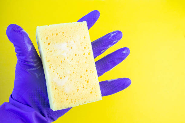 istock Hand in a rubber glove for cleaning. Kitchen sponge in hand. 1307123027