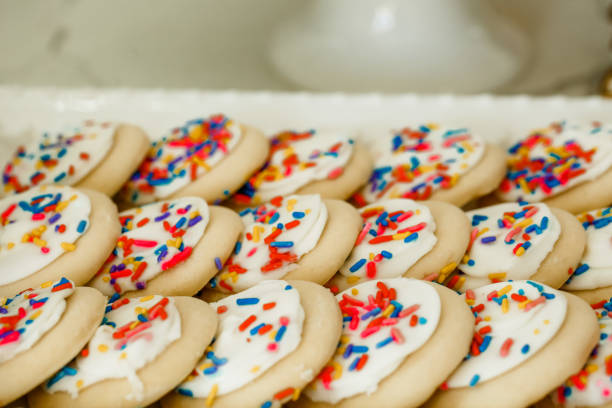 Sprinkled Goodness Delicious fluffy sugar cookies with white frosting snd rainbow sprinkles white sugar cookie stock pictures, royalty-free photos & images