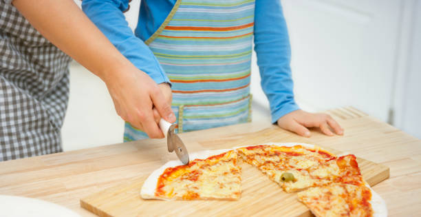 istock Woman and boy slicing pizza 1307131342