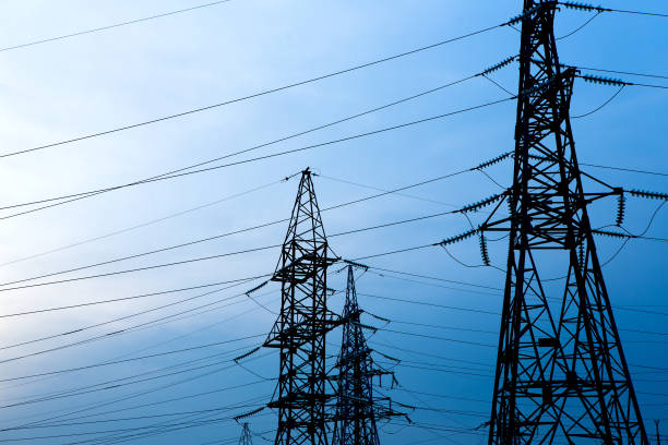 istock Electricity pylons on blue sky background. High voltage grid tower with wire cable at distribution station. 1307133118