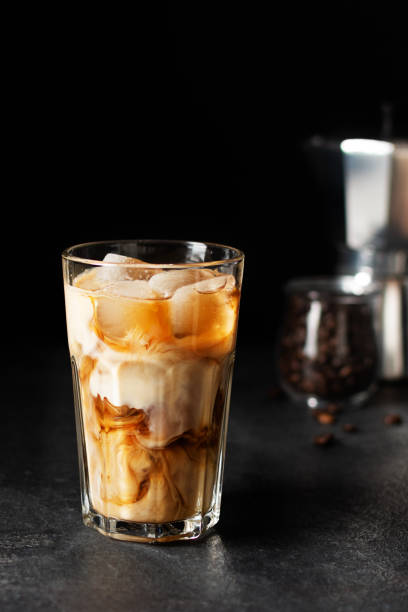 istock Iced coffee in a tall glass on black background. 1307138106