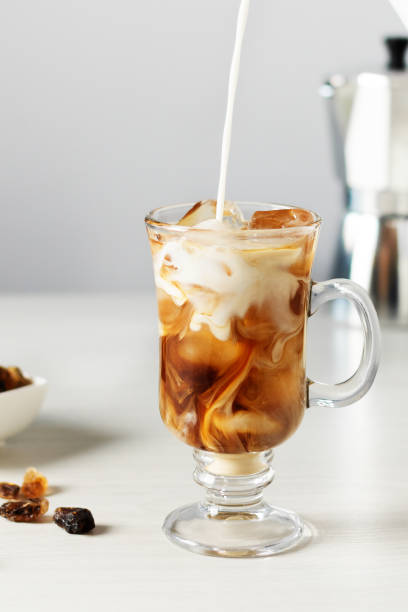 アイスコーヒーでグラスにミルクを注ぎます。 - カフェオレ ストックフォトと画像