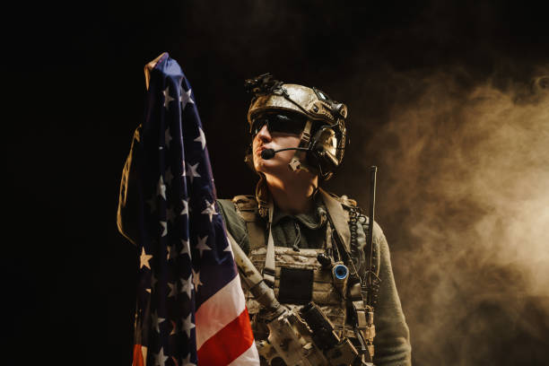 soldat de forces spéciales retenant le drapeau national des etats-unis dans l’obscurité - air force uniform armed forces military photos et images de collection