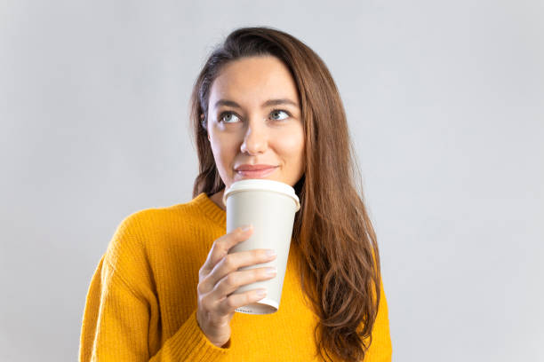istock Young woman drinking coffee from paper cup 1307140372