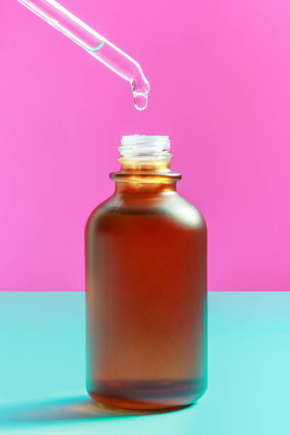 istock Bottle with serum and pipette on blue and pink background close-up. 1307141468