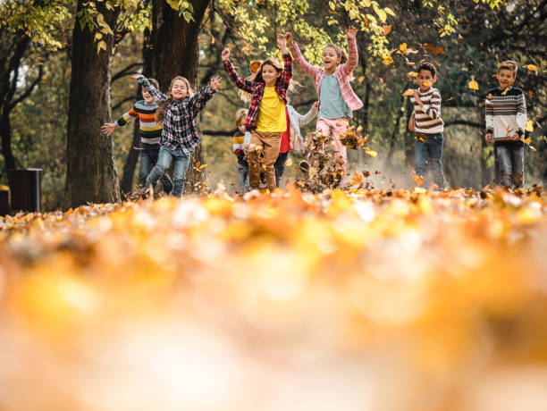 istock Hppy kids having fun while running through autumn leaves in the park. 1307141534