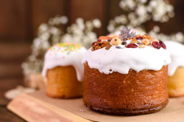 istock Festive cakes with white glaze, nuts and raisins with Easter eggs on the festive table 1307142224