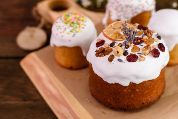 istock Festive cakes with white glaze, nuts and raisins with Easter eggs on the festive table 1307142245
