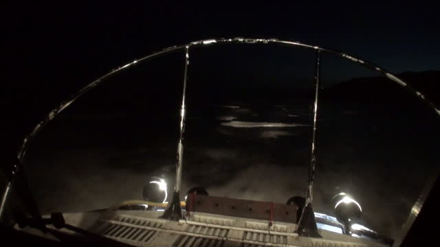 View from of moving airboat air glider on ice at night of Baikal.
