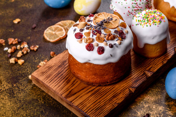 istock Festive cakes with white glaze, nuts and raisins with Easter eggs on the festive table 1307142374