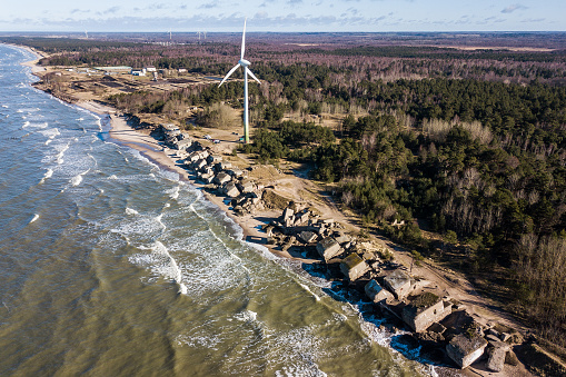 Aerial view of Liepaja Northern Forts, old abandoned fortifications at Baltic sea coast in Latvia and wind turbine