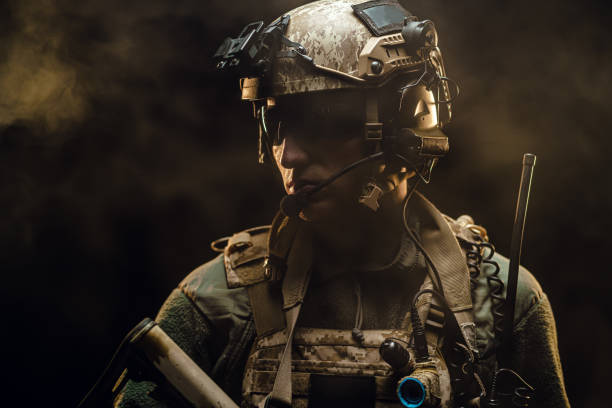 istock Special forces soldier with rifle on black background 1307143714