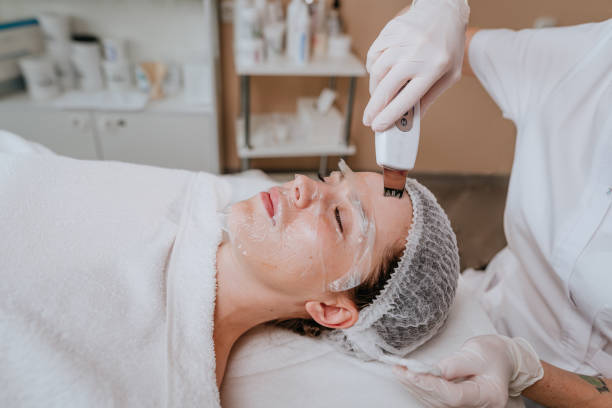 istock Esthetician making facial cleansing procedure using ultrasonic scin scrubber spatula 1307144047