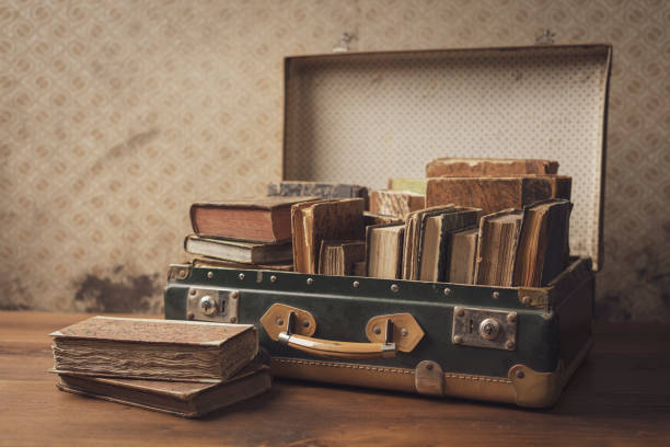 istock Old leather suitcase with books on the floor. 1307144668