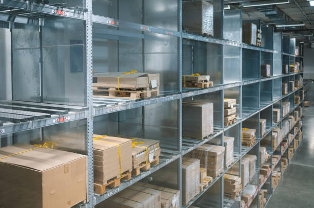 istock Lage retail warehouse saller Empty warehouse, view down the asile with shelves and boxes. 1307144954
