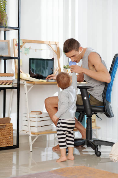 istock Father with baby sitting at home 1307146190