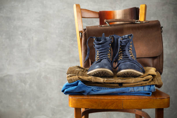 istock Stack of denim blue jeans near old wall background texture 1307147302
