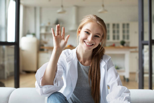 istock Smiling young woman influencer waving looking at camera talking making video chat, webcam view. 1307149708