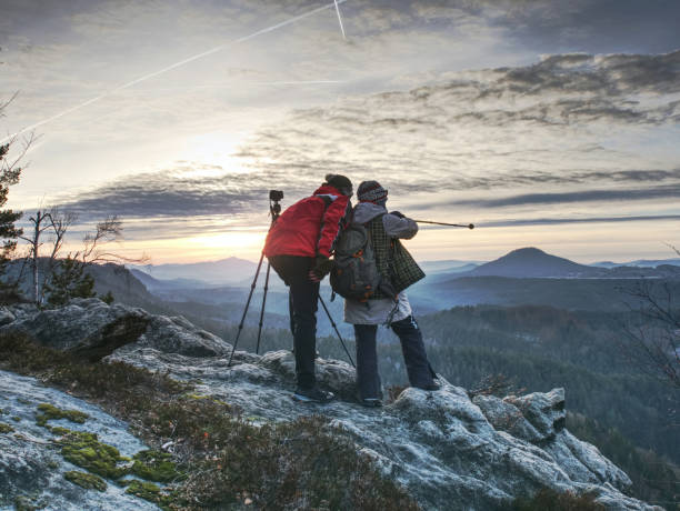 para lubi fotografować w dzikiej przyrodzie. fotografowie przyrody przebywają na summit rock. posłuchaj muse - behind photographer men mountain climbing zdjęcia i obrazy z banku zdjęć