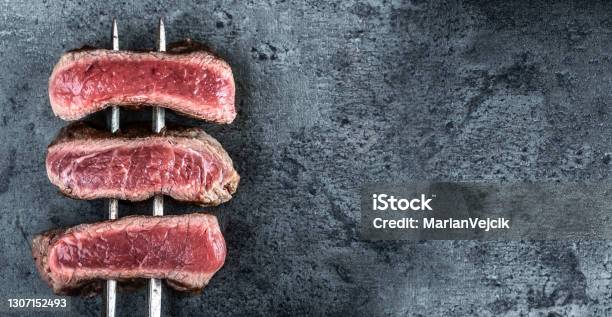 Skewed Steaks Of Beef Cooked On Hot Dark Stones Viewed From The Top Stock Photo - Download Image Now