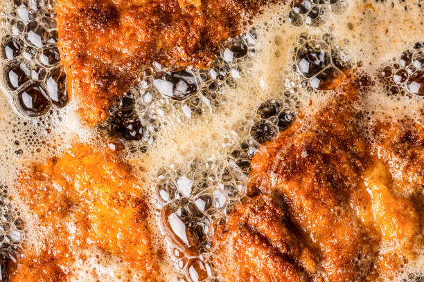 Detail of schnitzels in breadcrumbs sizzling in frying oil Detail of schnitzels in breadcrumbs sizzling in frying oil. schnitzel stock pictures, royalty-free photos & images