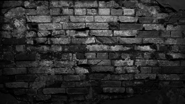 istock Black old brick wall. Collapsing brickwork. Grunge background with copy space for design. 1307154130