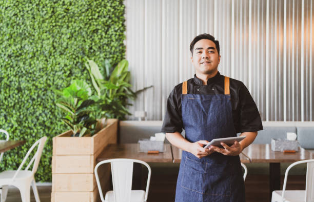 istock Small business owner standing with confident, holding digital tablet. 1307154391