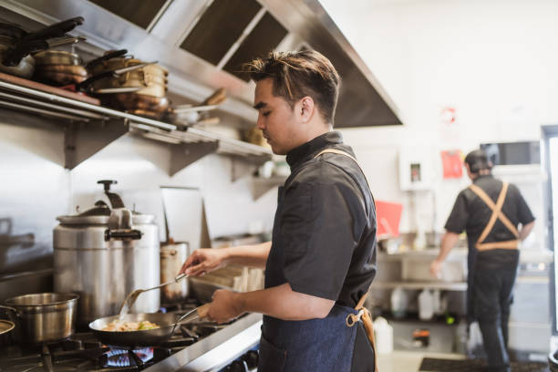 istock Small business man preparing dish in restaurant kitchen. 1307154559