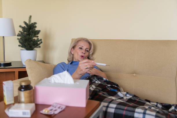 istock Sick Woman is Checking the Body Temperature Due to Flu or Cold. 1307155389