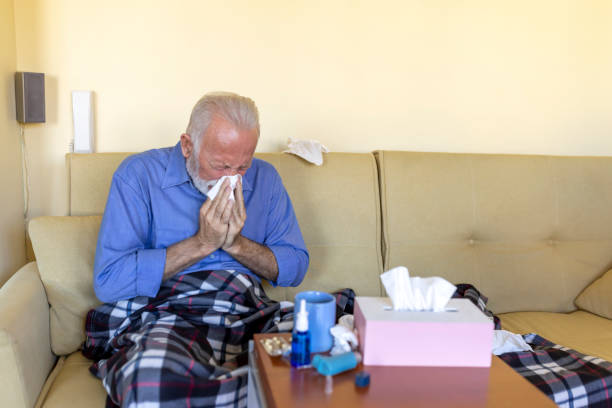istock Sick Senior Man is Lying in the Bed Due to High Temperature and Respiratory System Problems. 1307155540