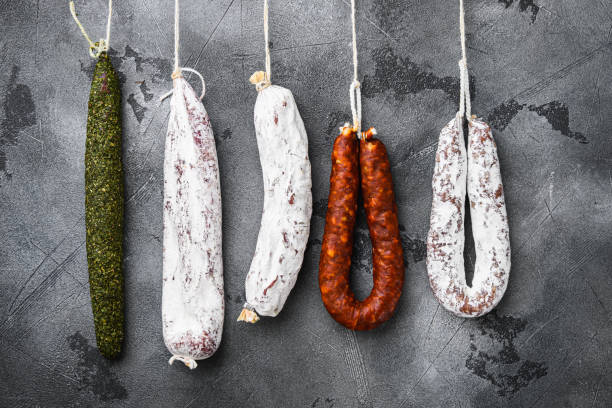 istock Spanish salami from a rack at market on grey textured background 1307157113