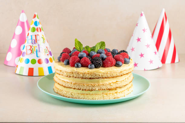 istock Homemade cake with fresh berries and birthday hat on bright background. 1307158462