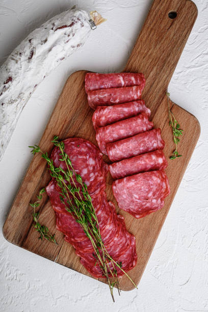 istock Salchichon whole and sliced cuts, spanish sausage on white surface, flat lay 1307158559
