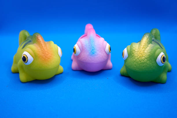 istock Three colorful chameleon figures made of plastic on a blue background 1307158585