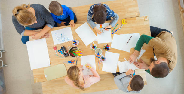 istock Overhead view of teachers helping children 1307158965