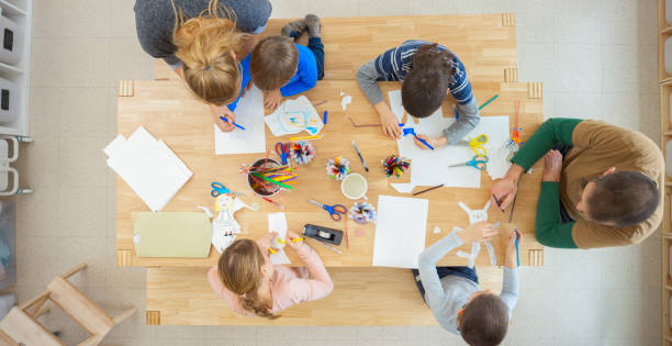 istock Overhead view of teachers helping children 1307158989