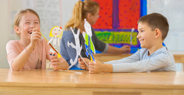 istock Smiling boy and girl playing with their puppets 1307159033