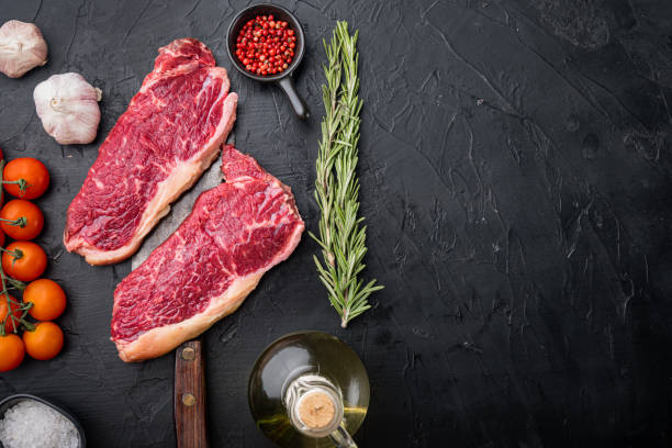 istock New York steak, raw beef meat , on black background, top view, with copy space for text 1307159317
