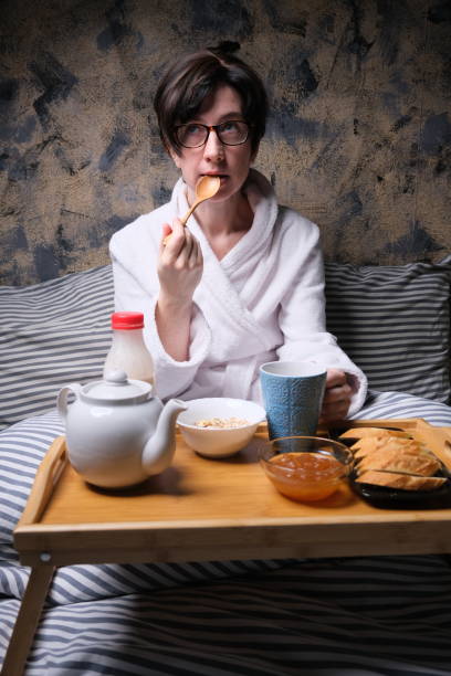 istock Mature woman is having breakfast in bed 1307161289