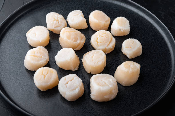 istock Fresh seafood, scallops, on black textured background 1307161852
