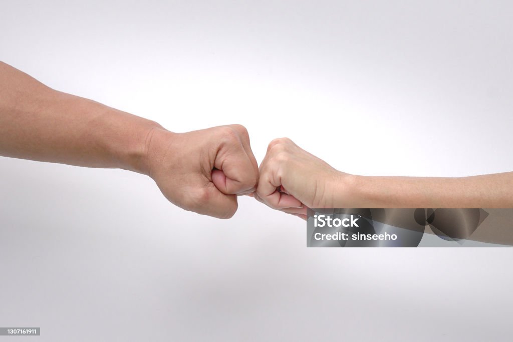 Close up of fist bump of a man and woman's hands against white background. Men Stock Photo