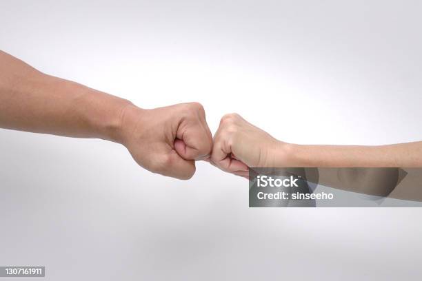 Close Up Of Fist Bump Of A Man And Womans Hands Against White Background Stock Photo - Download Image Now