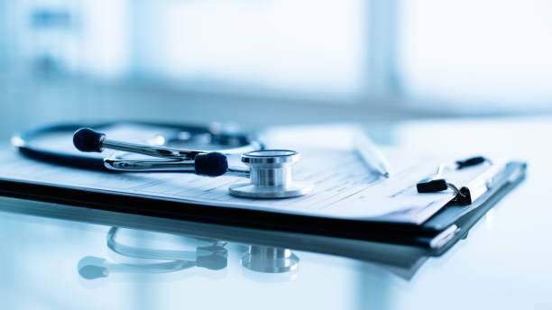 Stethoscope and pen laying on patient information blank close-up. Stethoscope and pen laying on patient information blank. stethoscope photos stock pictures, royalty-free photos & images
